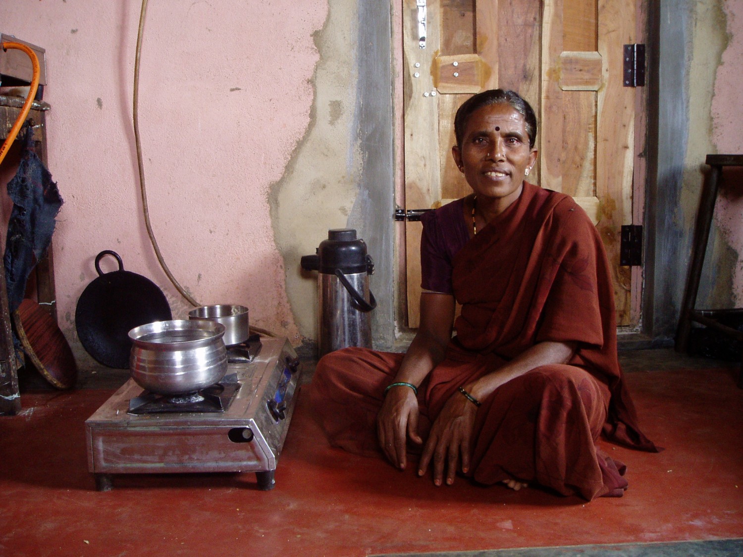 En kvinna lagar mat med hjälp av biogas