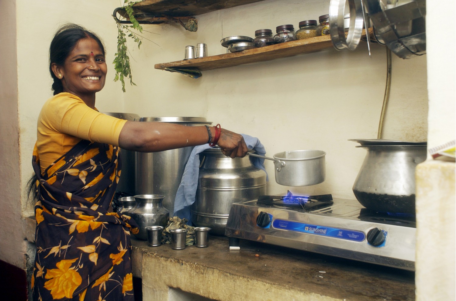 En kvinna vid sin spis som drivs av biogas